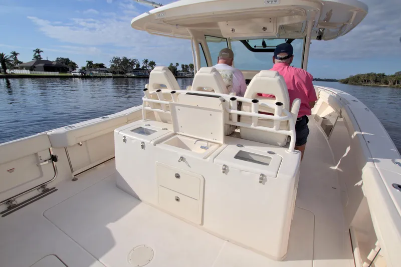 Lucky Penny II Yacht Photos Pics 2018 Grady-White Canyon 376 boat interior with two people seated, cruising on calm water.