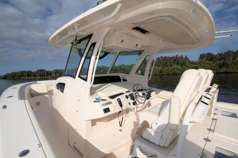 Lucky Penny II Yacht Photos Pics 2018 Grady-White Canyon 376 boat interior with helm and seating, on calm water.