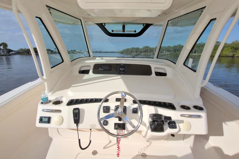 Lucky Penny II Yacht Photos Pics 2018 Grady-White Canyon 376 helm with steering wheel and controls on a sunny day.