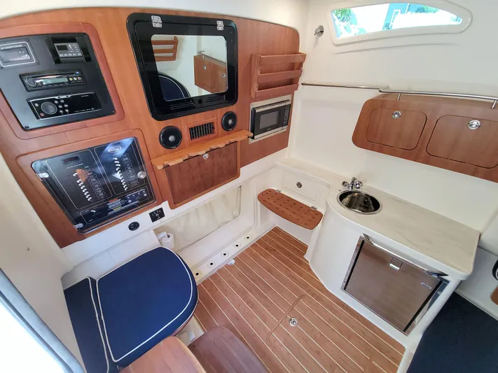 Lucky Penny II Yacht Photos Pics 2018 Grady-White Canyon 376 cabin interior with wood accents, seating, and kitchenette.