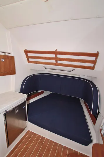 Lucky Penny II Yacht Photos Pics 2018 Grady-White Canyon 376 cabin interior with blue cushioned seating and wooden accents.