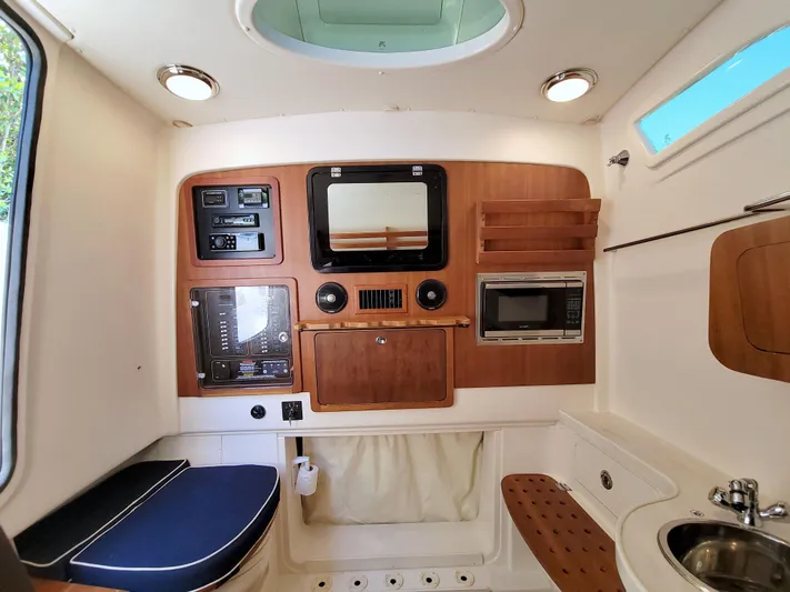 Lucky Penny II Yacht Photos Pics 2018 Grady-White Canyon 376 cabin interior with wood paneling, seating, and kitchenette amenities.