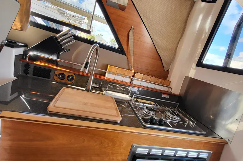 Tranquila Yacht Photos Pics 2023 Cutwater C-288 Coupe kitchen with stove, sink, and cutting board.