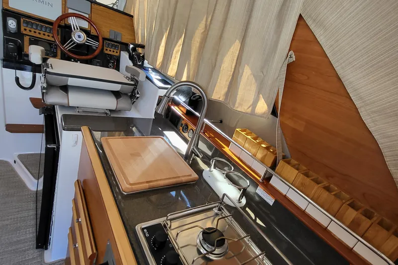 Tranquila Yacht Photos Pics 2023 Cutwater C-288 Coupe interior with helm, kitchen, and modern amenities.