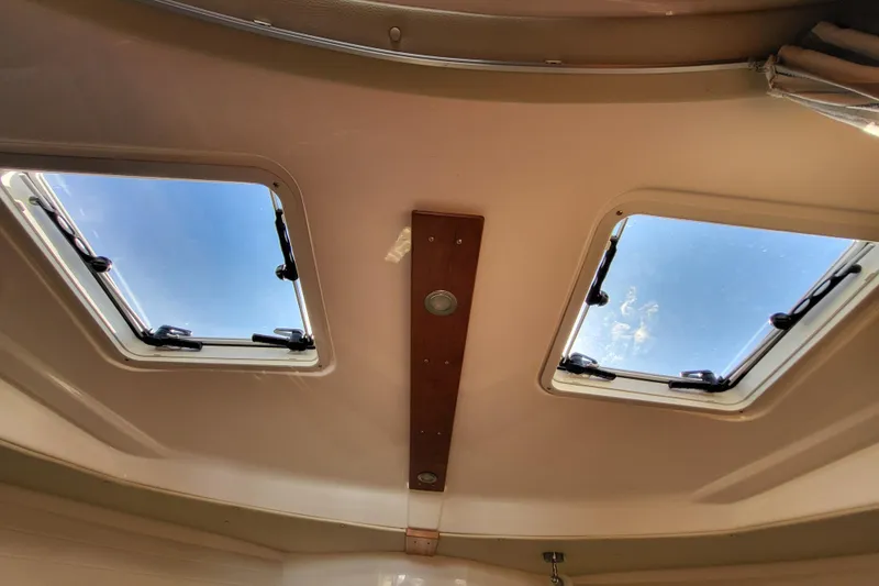 Tranquila Yacht Photos Pics Interior view of 2023 Cutwater C-288 Coupe, featuring dual skylights and wooden paneling.
