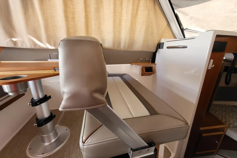 Tranquila Yacht Photos Pics Interior of 2023 Cutwater C-288 Coupe, featuring a sleek seating area and wooden table.