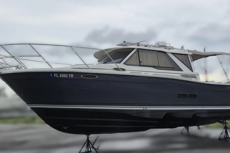 Tranquila Yacht Photos Pics 2023 Cutwater C-288 Coupe boat on stands, side view, overcast sky.