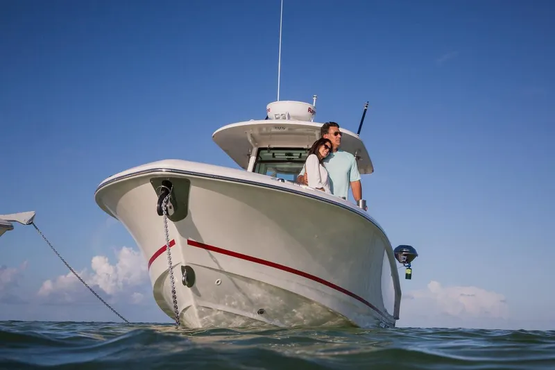  Yacht Photos Pics Manufacturer Provided Image: 2025 Boston Whaler 250 Outrage boat on water, couple enjoying sunny day.