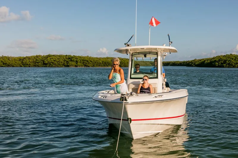  Yacht Photos Pics Manufacturer Provided Image: 2025 Boston Whaler 250 Outrage boat on water with passengers, scenic background.