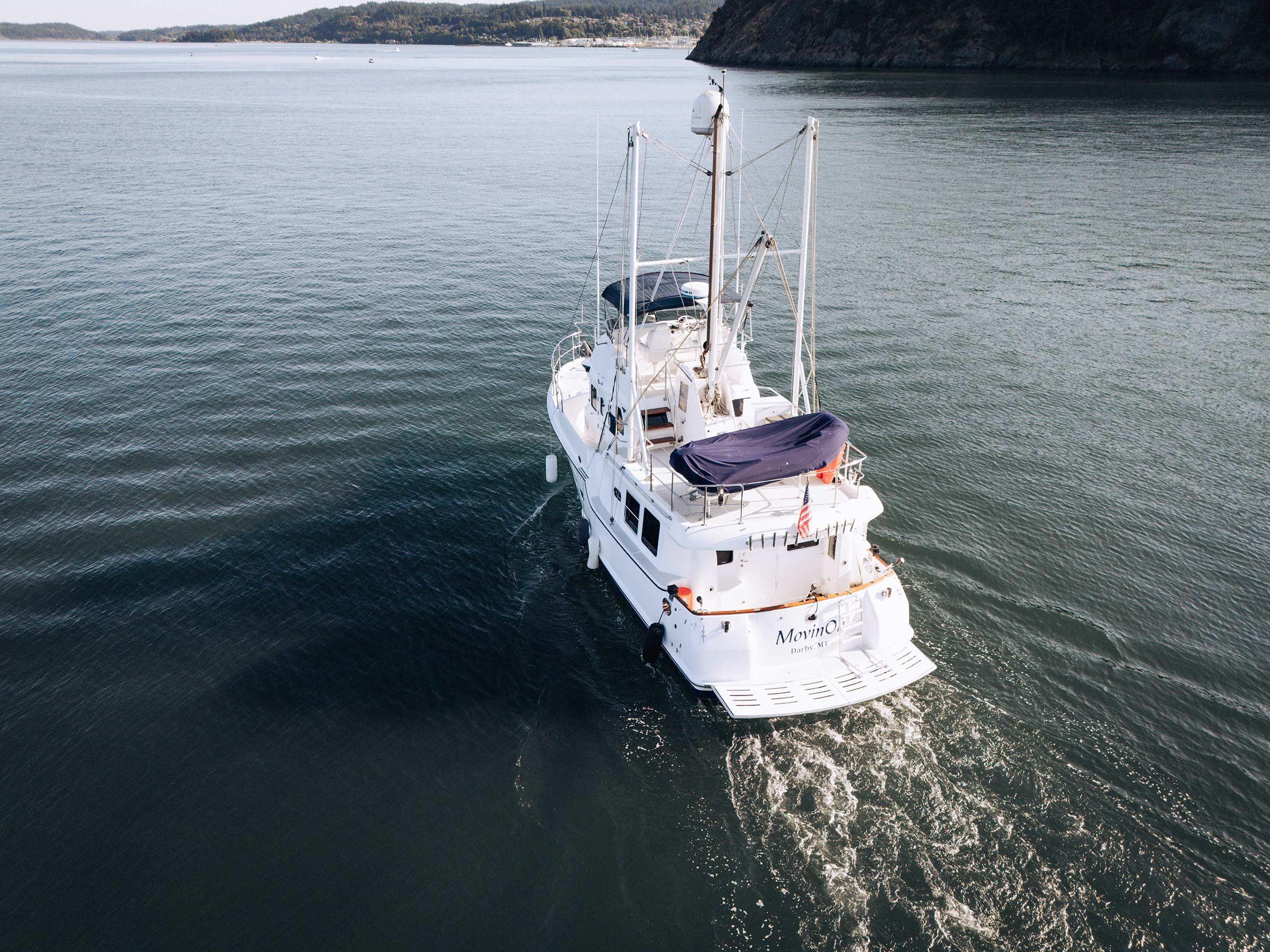 Nordhavn 43 yacht from 2004 cruising on calm waters, aerial view.