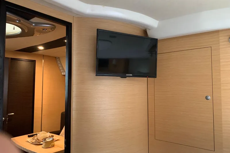  Yacht Photos Pics Interior of 2009 Cranchi Mediterranee 43 HT yacht with mounted TV and wooden paneling.
