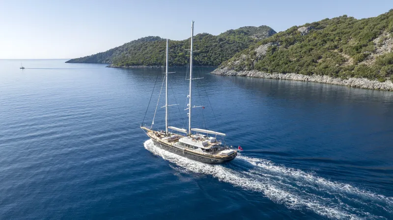 Atlantika Yacht Photos Pics Custom 2013 sailing yacht cruising in serene blue waters near lush green hills.