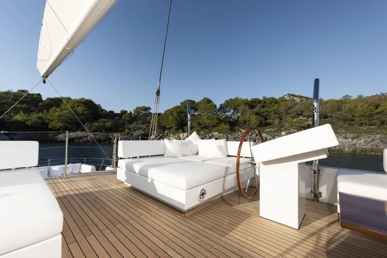 Atlantika Yacht Photos Pics Luxurious 2013 custom sailing yacht deck with white seating, wooden flooring, and scenic coastal view.