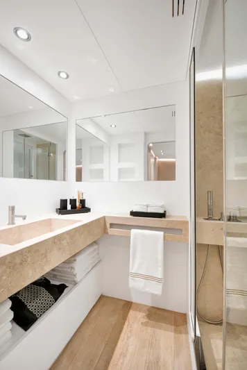 Atlantika Yacht Photos Pics Luxurious yacht bathroom with modern fixtures, large mirror, and elegant wood flooring.