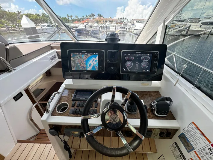 Yacht Photos Pics Helm of 2015 Cruisers Yachts 48 Cantius with navigation screens and steering wheel.