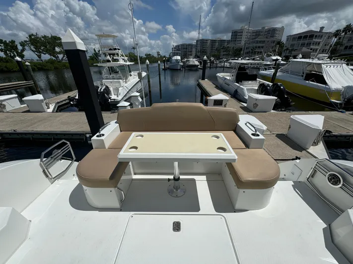  Yacht Photos Pics 2015 Cruisers Yachts 48 Cantius, docked with seating area and table, under cloudy sky.
