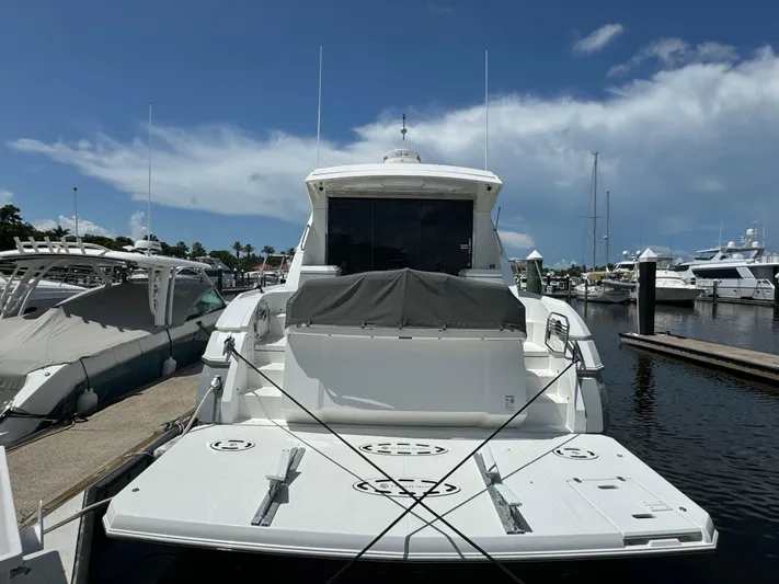  Yacht Photos Pics 2015 Cruisers Yachts 48 Cantius docked at marina under clear blue sky.