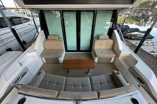 No Agenda Yacht Photos Pics 2016 Tiara Yachts C44 Coupe cockpit with plush seating and wooden table.
