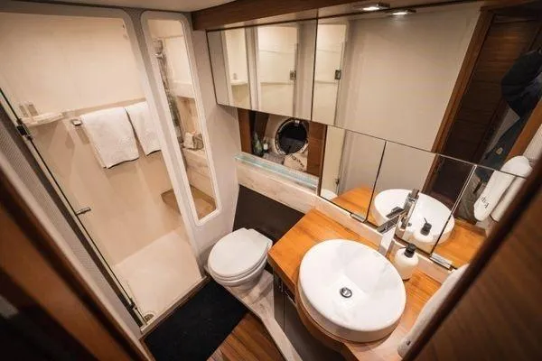 No Agenda Yacht Photos Pics Luxurious bathroom in 2016 Tiara Yachts C44 Coupe with modern fixtures and wooden accents.