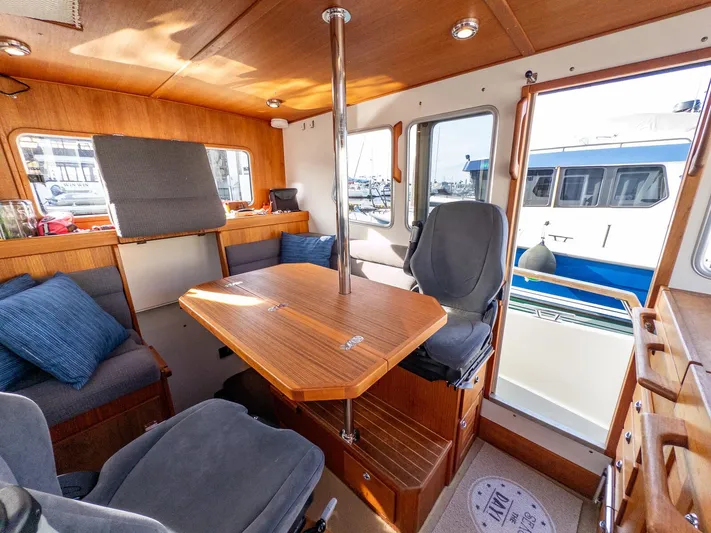  Yacht Photos Pics Interior of 2018 Targa 27.1 boat with wooden table and seating area.