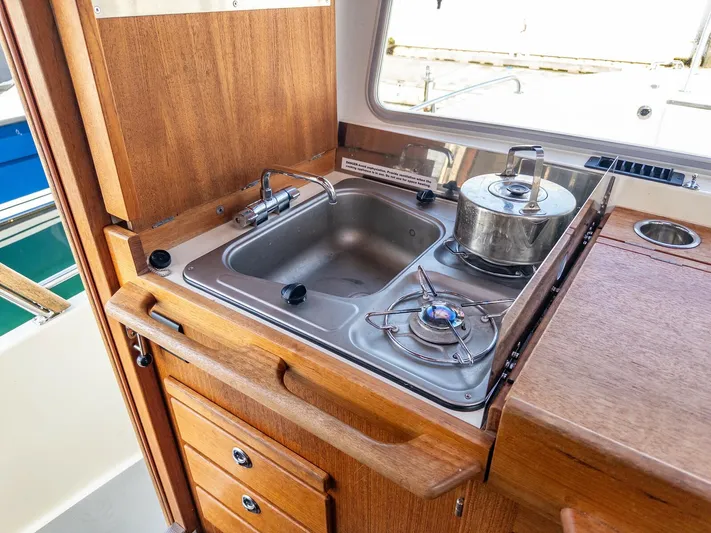  Yacht Photos Pics Compact kitchen area in a 2018 Targa 27.1 boat with sink and stove.