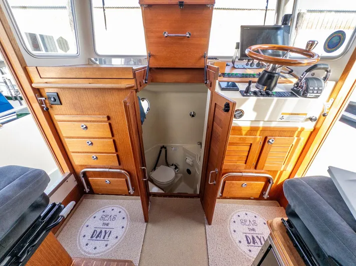  Yacht Photos Pics 2018 Targa 27.1 boat interior with wooden cabinetry and helm, featuring nautical-themed decor.