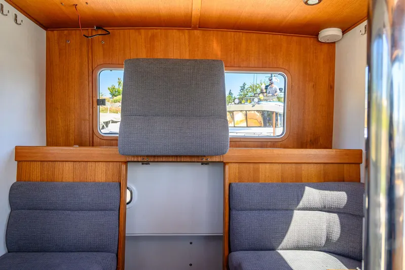  Yacht Photos Pics Interior of 2018 Targa 27.1 boat with wooden paneling and gray seating.