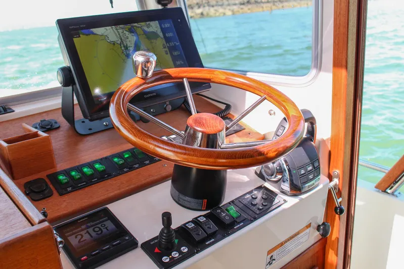  Yacht Photos Pics Helm of 2018 Targa 27.1 boat with wooden steering wheel and navigation equipment.