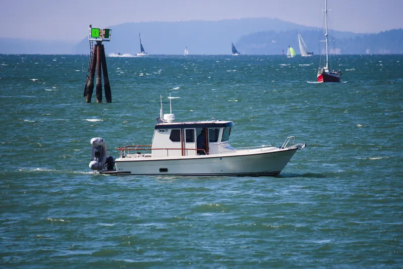  Yacht Photos Pics 2018 Targa 27.1 boat cruising on a sunny day with sailboats in the background.