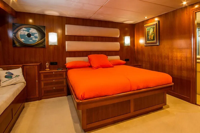  Yacht Photos Pics Luxurious 2004 Explorer Seaton 85 yacht bedroom with vibrant orange bedding and elegant wood paneling.