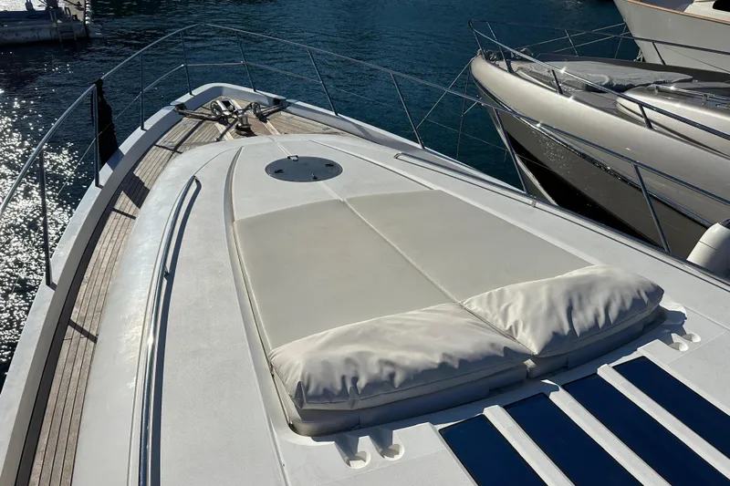  Yacht Photos Pics Luxury 2006 Princess V70 yacht deck with sunbathing area, docked in serene waters.