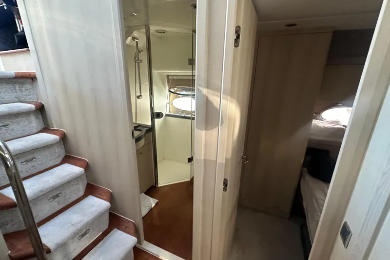  Yacht Photos Pics Interior of 2006 Princess V70 yacht showing stairs, bathroom, and cabin entrance.