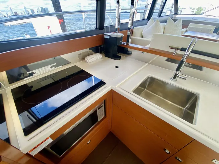  Yacht Photos Pics Modern kitchen area on a 2015 Prestige 500 yacht with sink and stovetop.