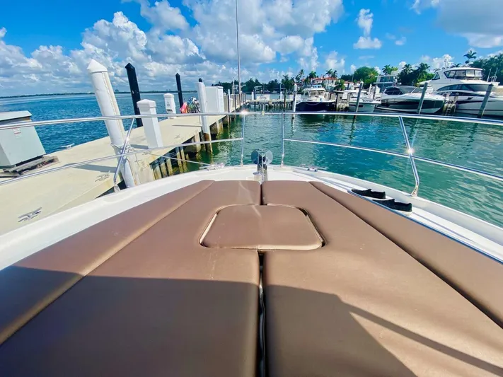  Yacht Photos Pics Bow view of 2015 Prestige 500 yacht docked at marina under blue sky.