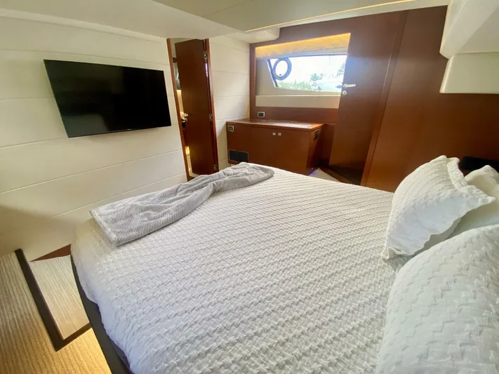  Yacht Photos Pics Luxurious cabin interior of a 2015 Prestige 500 yacht with a cozy bed and TV.