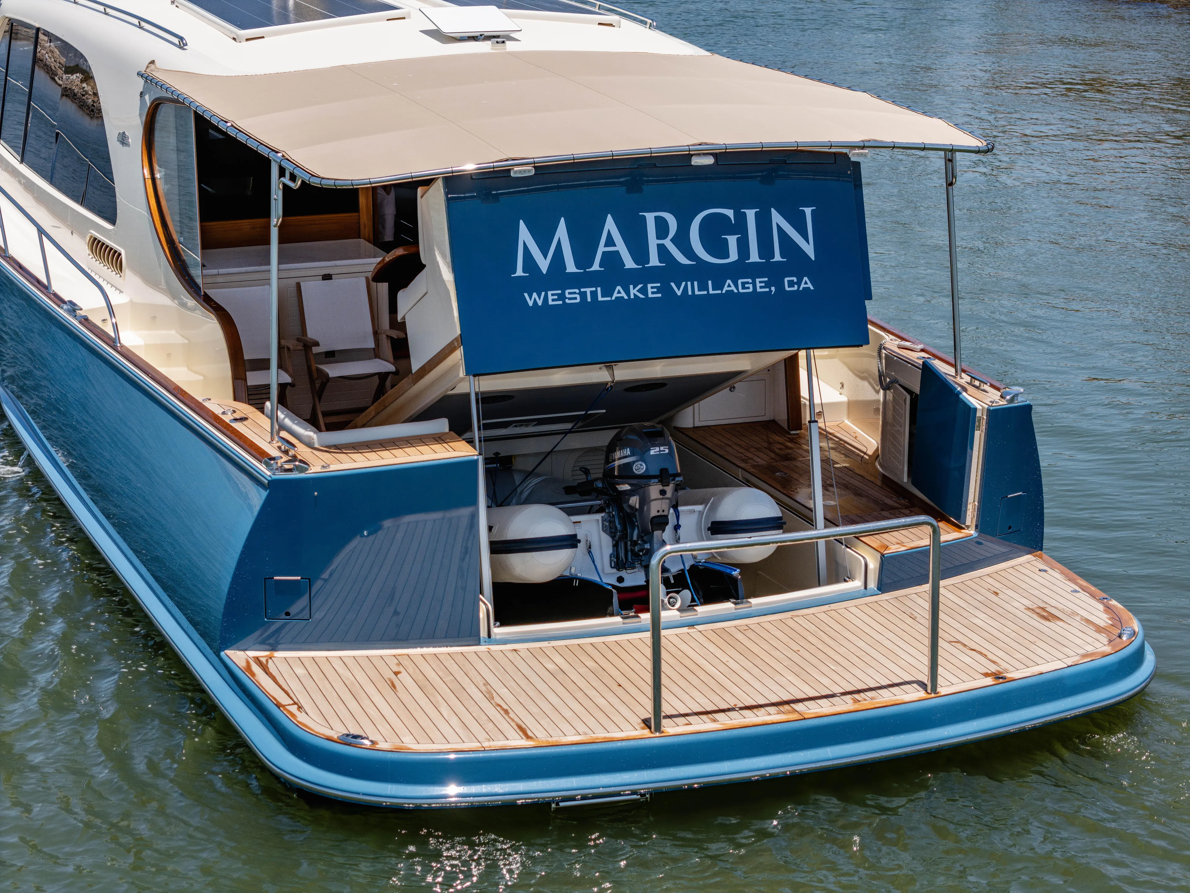 Margin Yacht Photos Pics 2025 Palm Beach Motor Yachts PB70, blue hull, rear view with canopy, docked in water.