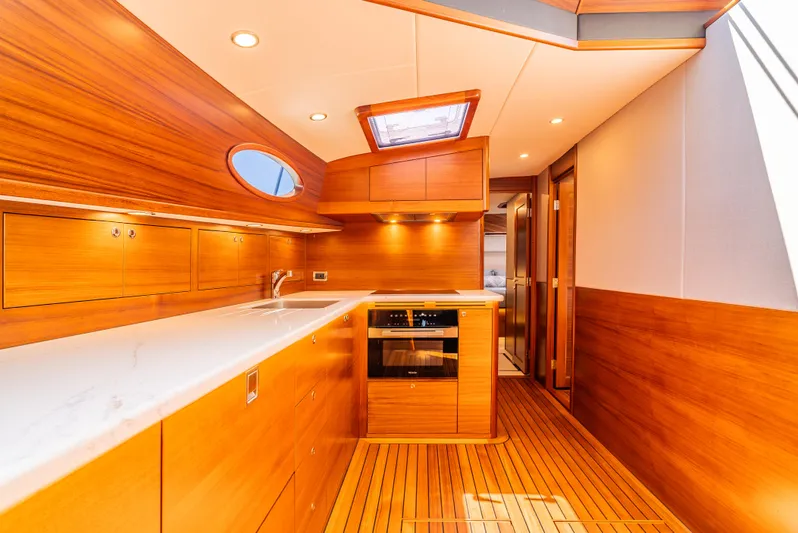 Margin Yacht Photos Pics Luxurious 2025 Palm Beach Motor Yachts PB70 interior with sleek wooden finishes and modern kitchen amenities.