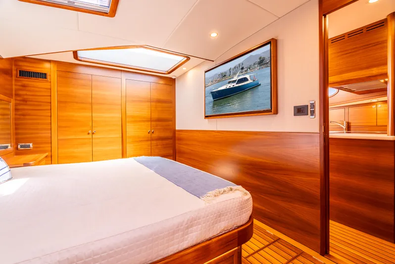 Margin Yacht Photos Pics Luxurious cabin interior of 2025 Palm Beach Motor Yachts PB70 with wood paneling and artwork.