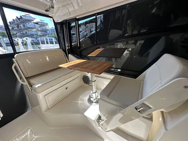  Yacht Photos Pics Interior of 2023 Boston Whaler 325 Conquest with seating and wooden table.