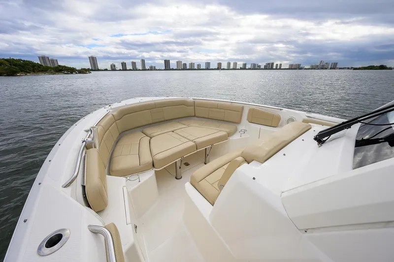  Yacht Photos Pics 2019 Pursuit S 328 Sport boat with spacious seating, overlooking a city skyline on the water.