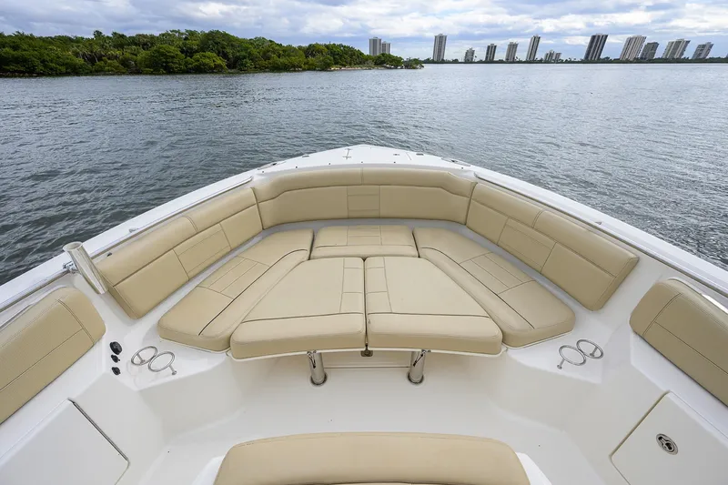  Yacht Photos Pics 2019 Pursuit S 328 Sport boat with spacious seating, overlooking calm waters and distant skyline.