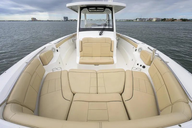  Yacht Photos Pics 2019 Pursuit S 328 Sport boat with spacious beige seating on calm water.