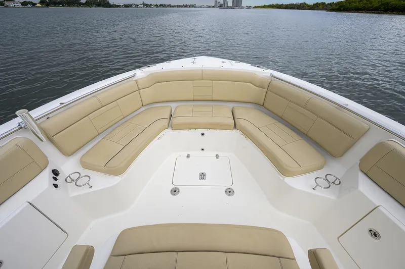  Yacht Photos Pics 2019 Pursuit S 328 Sport boat with spacious beige seating on calm water.