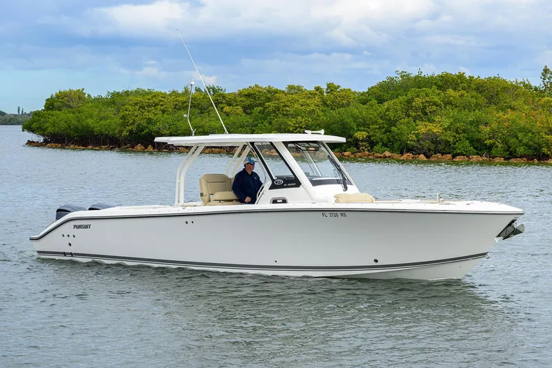  Yacht Photos Pics 2019 Pursuit S 328 Sport boat cruising on a calm waterway with lush greenery.
