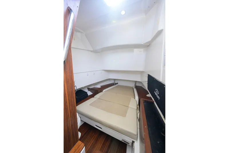  Yacht Photos Pics 2019 Pursuit S 328 Sport cabin interior with cushioned seating and wooden accents.