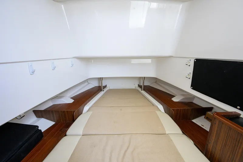  Yacht Photos Pics 2019 Pursuit S 328 Sport cabin interior with cushioned seating and wooden accents.