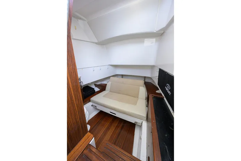  Yacht Photos Pics 2019 Pursuit S 328 Sport cabin interior with wooden flooring and cushioned seating.