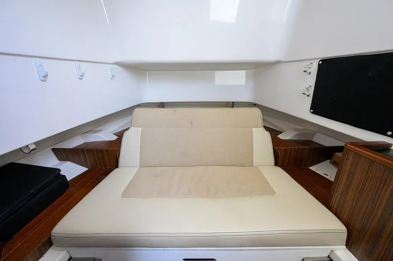  Yacht Photos Pics 2019 Pursuit S 328 Sport cabin interior with beige seating and wooden accents.