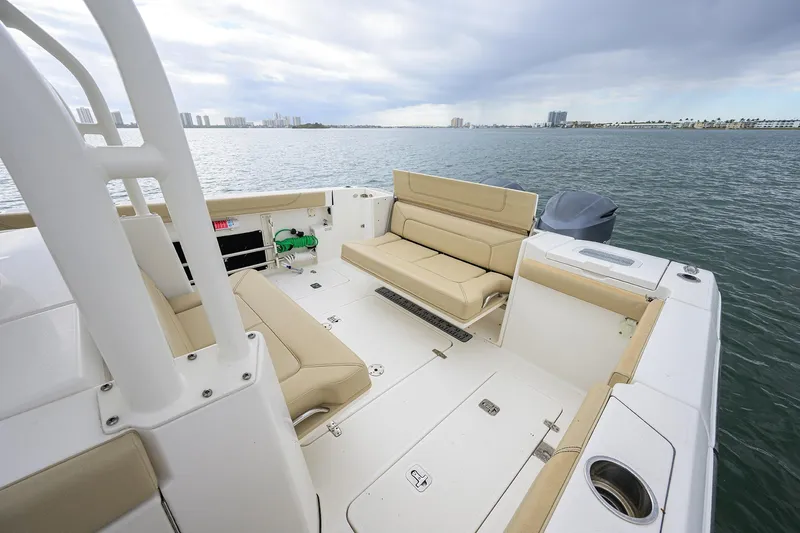  Yacht Photos Pics 2019 Pursuit S 328 Sport boat interior with beige seating, overlooking calm waters.