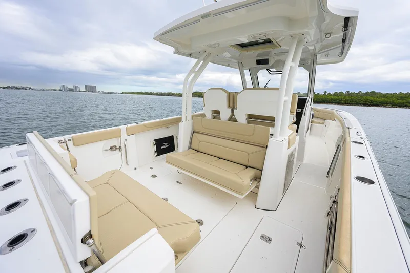  Yacht Photos Pics 2019 Pursuit S 328 Sport boat interior with beige seating, on calm water.